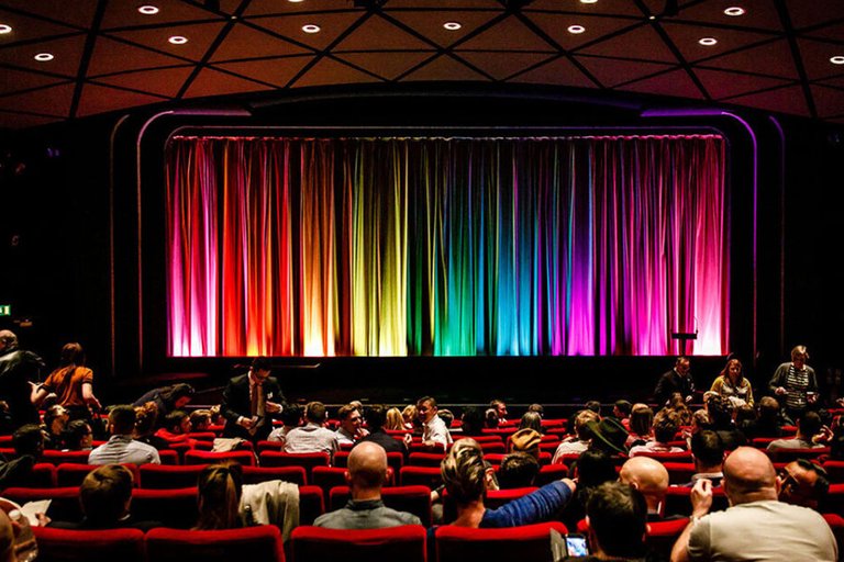 Rainbow coloured curtain at the front of a cinema auditorium